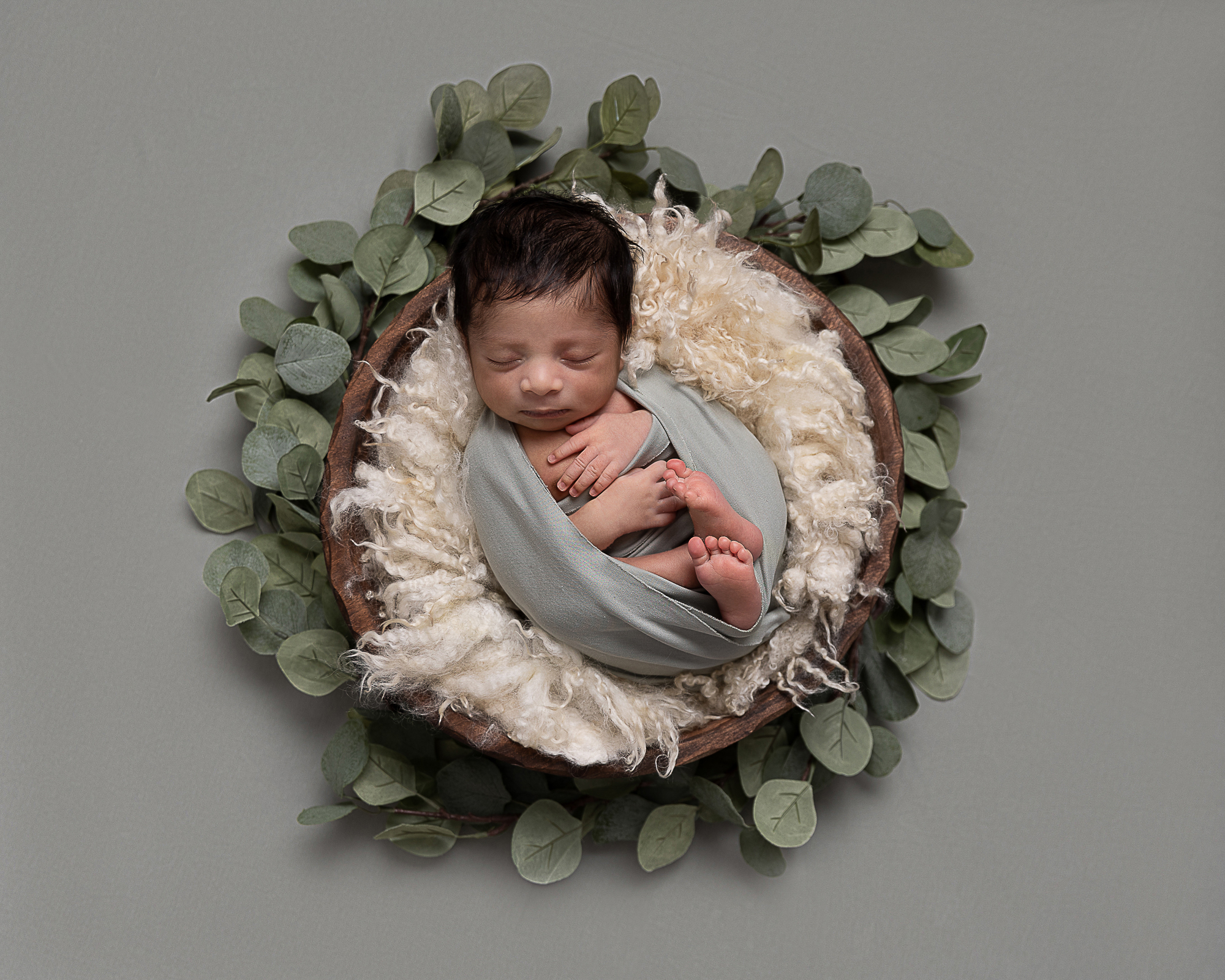 Baby boy on a bed of leaves, taken by a Newborn Photographer in Carshalton